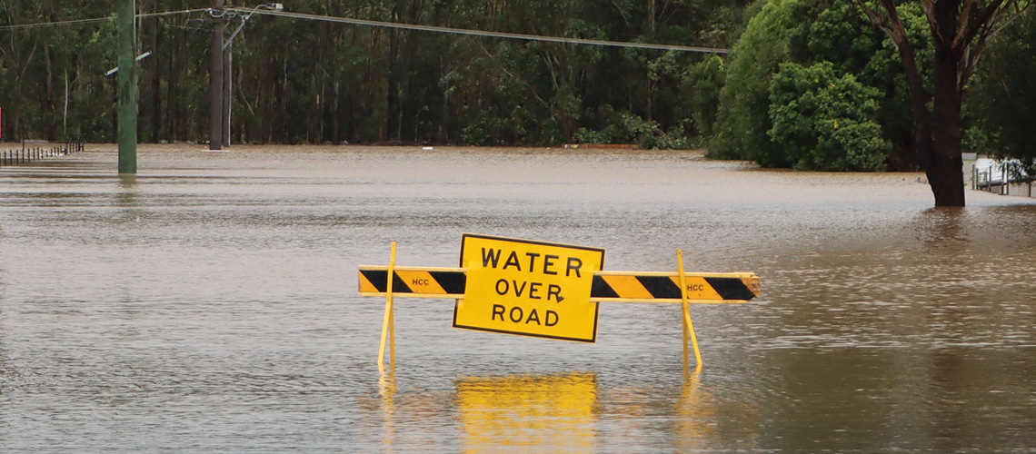 flooded road with warning sign