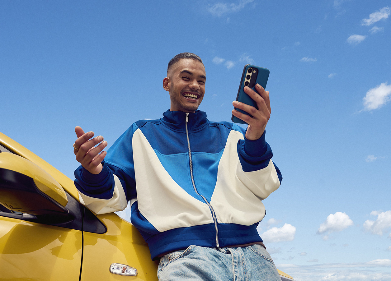 Male by car on phone