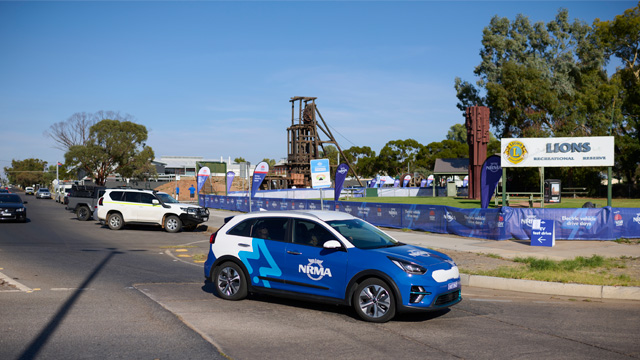 blue nrma electric vehicle driving on the road