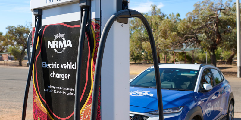 blue nrma vehicle parked behind electric vehicle charger