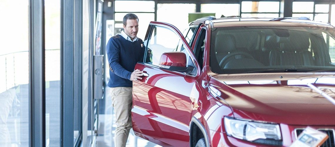 Man in a car showroom looking to buy a business vehicle