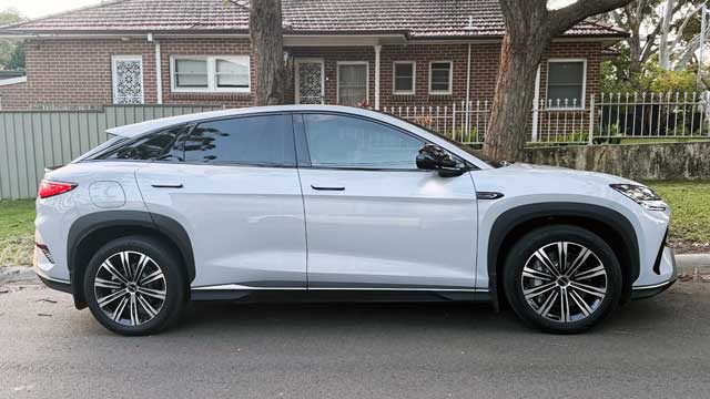 A light grey BYD Sealion 7 seen from the side on a street 