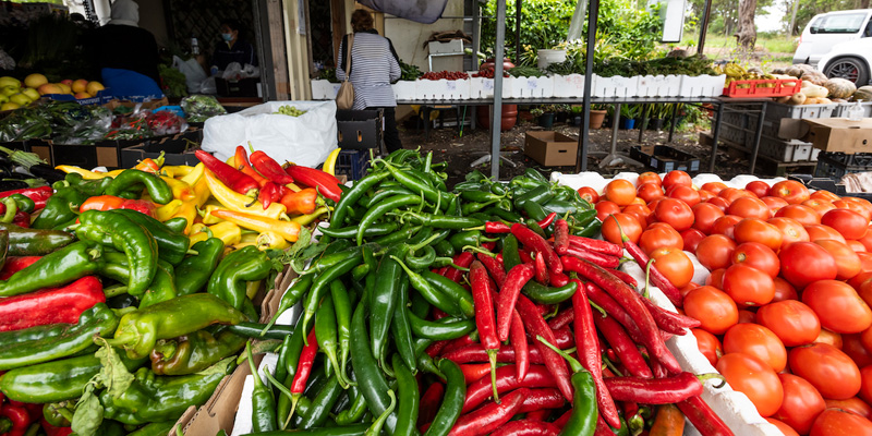 a collection of chillies, fruits and vegetables at a market