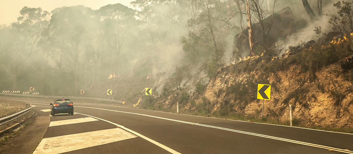 Car on the road in a bushfire