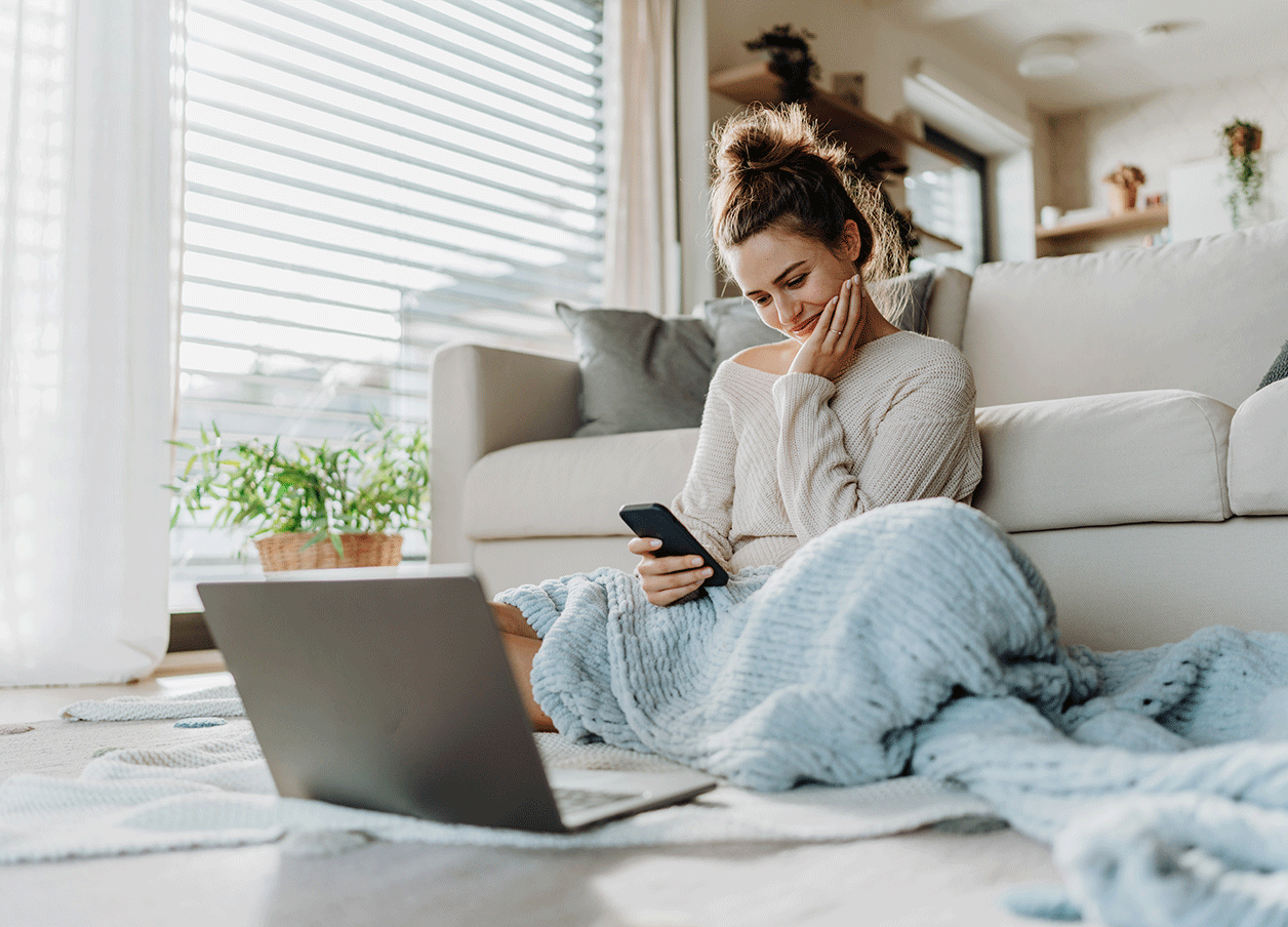 woman smiling at phone on floor