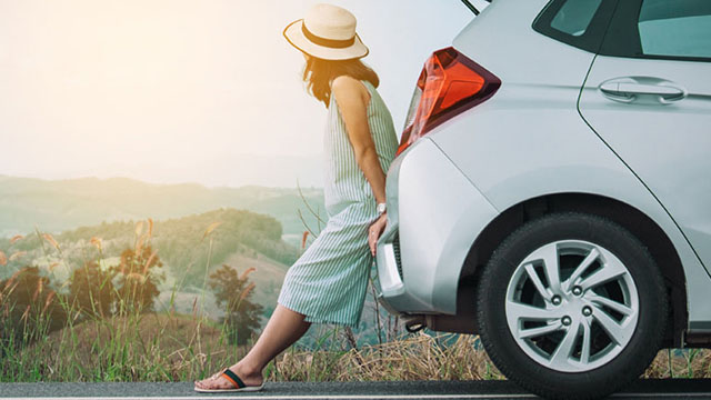 Woman leaning on her car