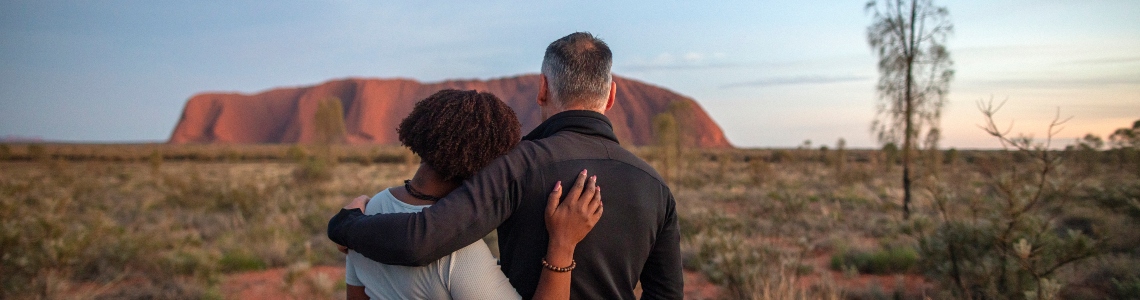 Couple looking at Uluru sunset