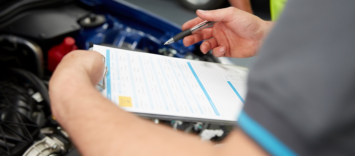 Mechanic checks vehicle safety sheet