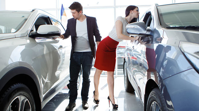 Young couple looking at new cars