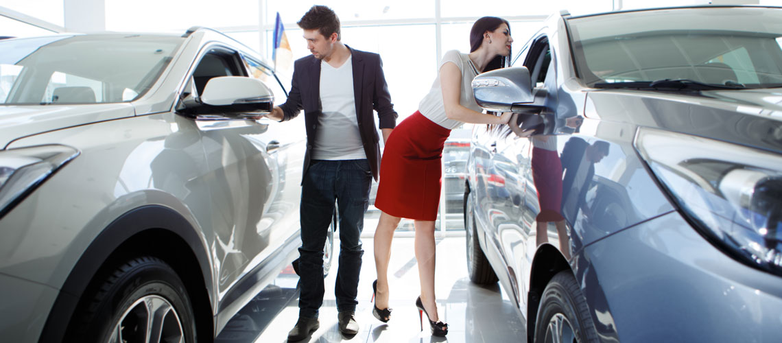 Young-couple-looking-at-new-cars