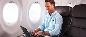 Business man with laptop flying Qantas
