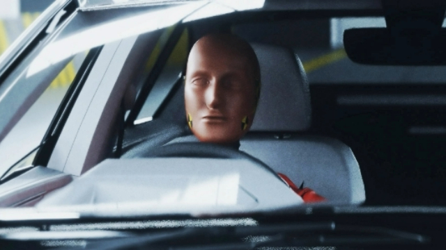 A crash test dummy sitting in the driver's seat of a car.