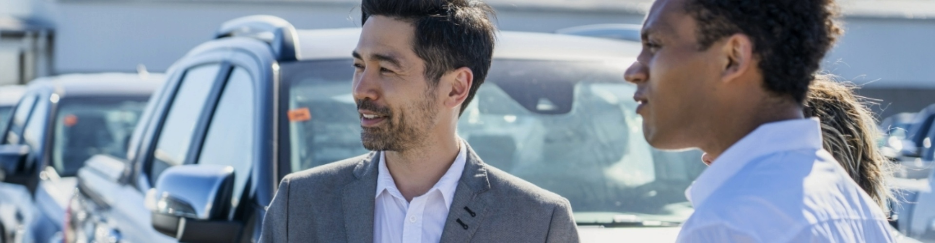 Two men and a woman appearing to have a conversation and looking to the left.