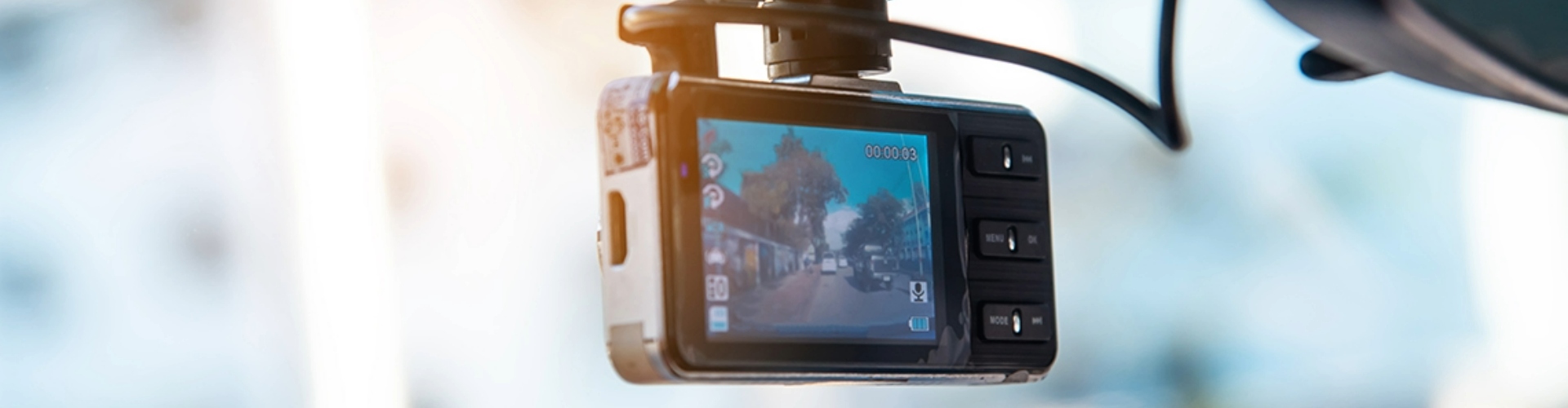 View of a dashcam installed behind a car review mirror.