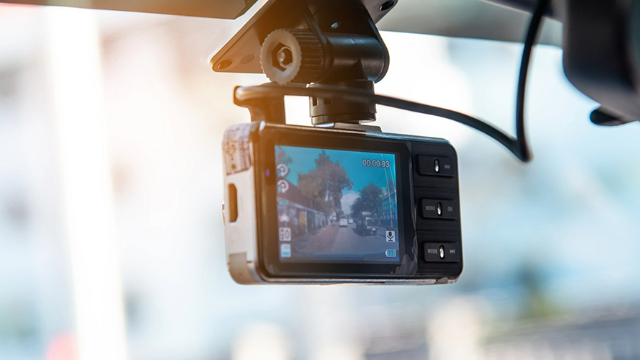View of a dashcam installed behind a car review mirror.