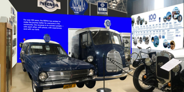 Museum exhibit of a vintage, NRMA branded car and combi van next to a hundred year history of the NRMA along the wall. 