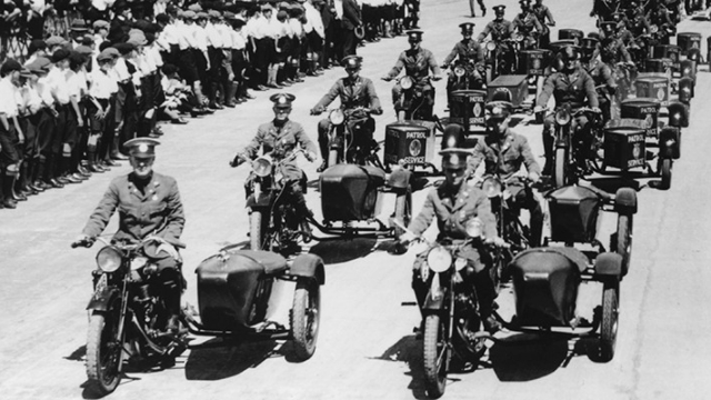 fleet of NRMA patrolmen, two a breast, on motorcycles leading the procession crossing the sydney harbour bridge at its opening ceremony in 1932