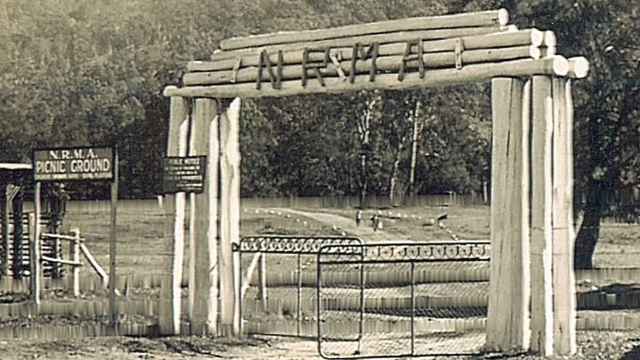 1930s black and white picture of the gate and wooden archway entrance to an NRMA motor park picnic and camping ground