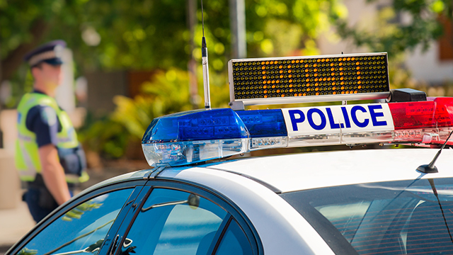 in focus lightbar system on a police car with a police man blurred in the background