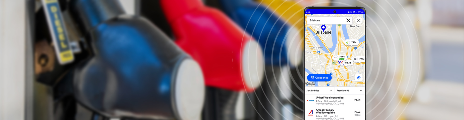 image of mobile phone with fuel app open in foreground for Brisbane area with blurred image of fuel bowser in the background