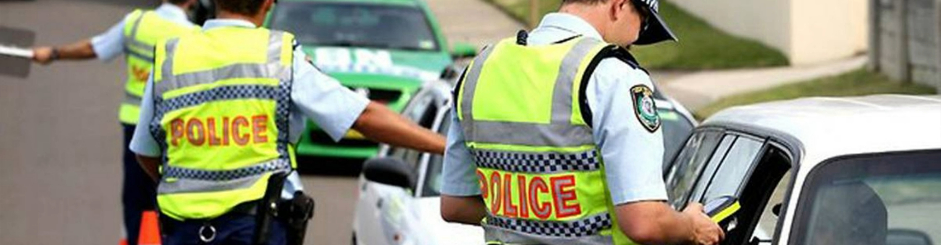 nsw-police-rbt-stop-1920x500 Police officers stopping a line of cars for random breath testing on a sunny day.