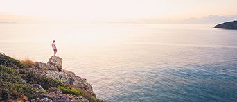Person on rock watching sunrise, QLD