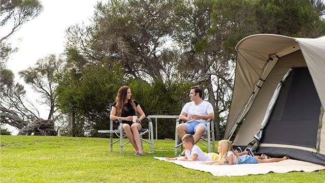 a family rest outside a tent