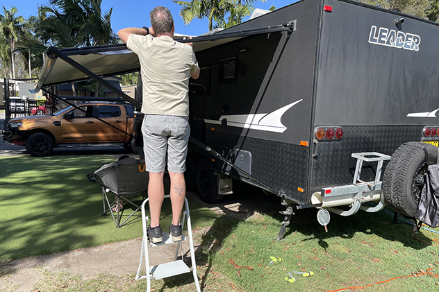 Using a step ladder to set up a caravan