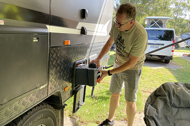 Man inserting toilet casette into caravan