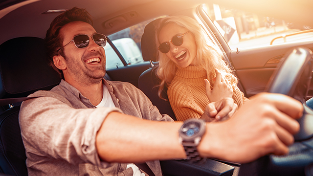 Man and woman in a car wearing sunglasses