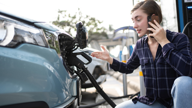 Worried person on phone while charging EV