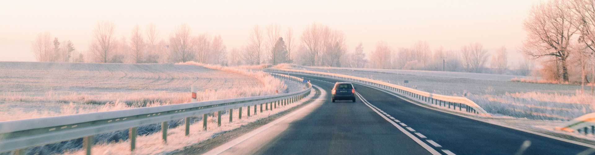 A car driving in the countryside on a frosty morning