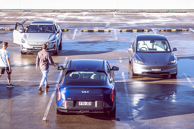 Two men walking to a Polestar 2, Kia EV4, and Tesla Model 3