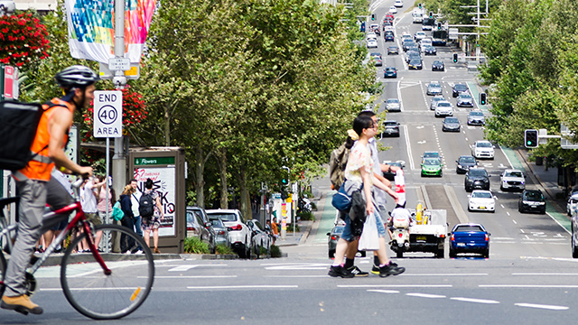 Cyclist, pedestrians and cars on William St, Sydney