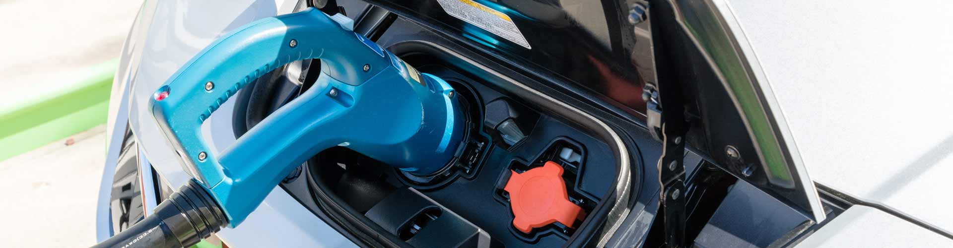 Pearland, Texas - March 21, 2018: New 2018 Nissan Leaf electric car plugged in to charge battery at the EVgo charging station A blue CHAdeMO plug inserted into Nissan Leaf