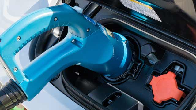 A blue CHAdeMO plug inserted into Nissan Leaf