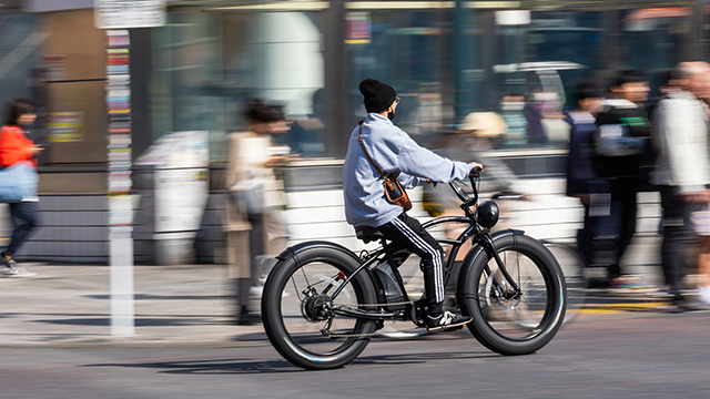 A person riding an e-bike on a road