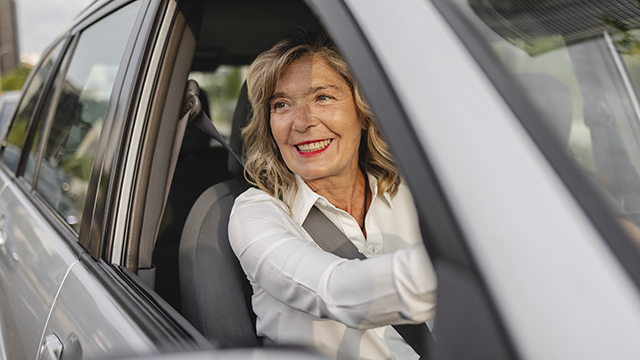 A woman driving a car wearing a seatbelt