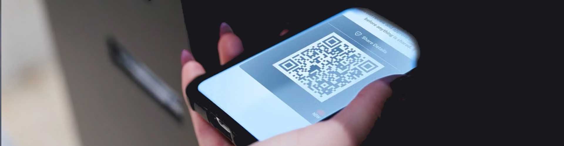 Hand holding phone with qr code showing