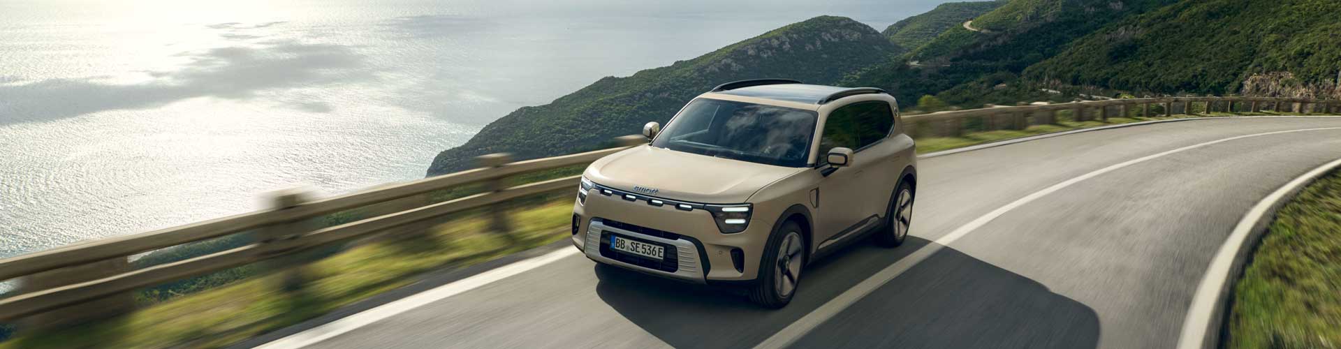 Smart #5 driving on road above hilly coastline