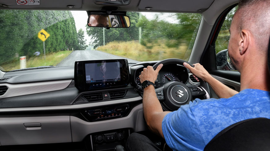 Automotive journslist driving a car seen from back row