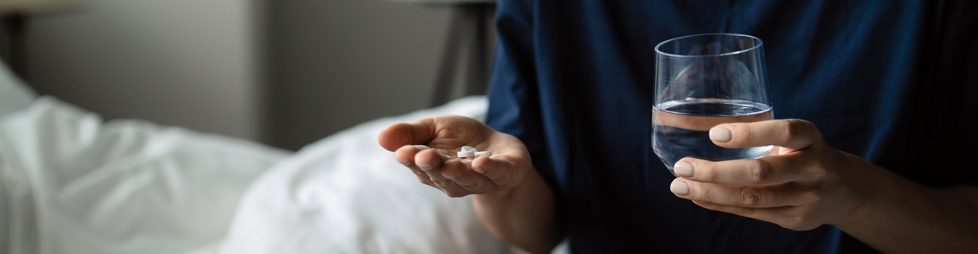 A man about to take medicine with water.