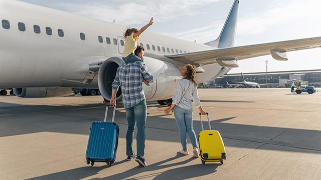 A family walking on the tarmac towards a plane