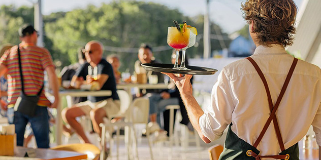 man serving drinks on a sunny patio
