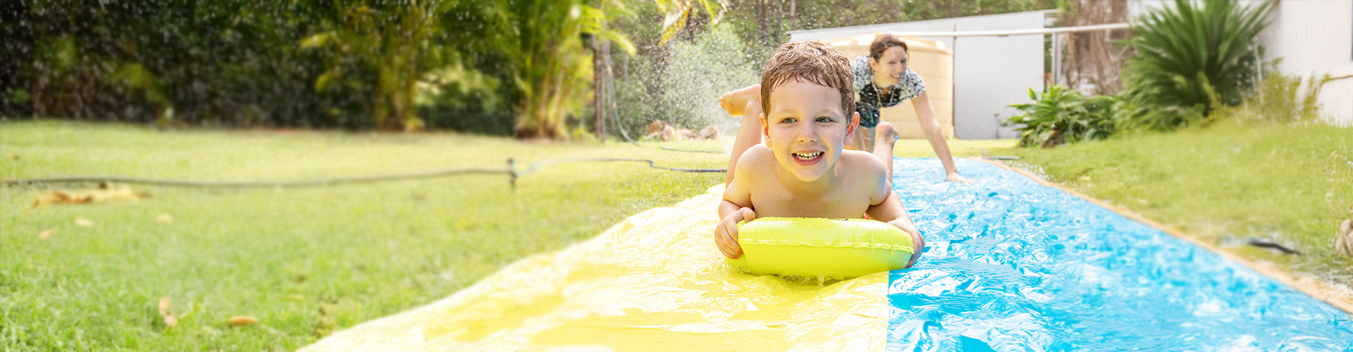 A young boy on a slip n slide