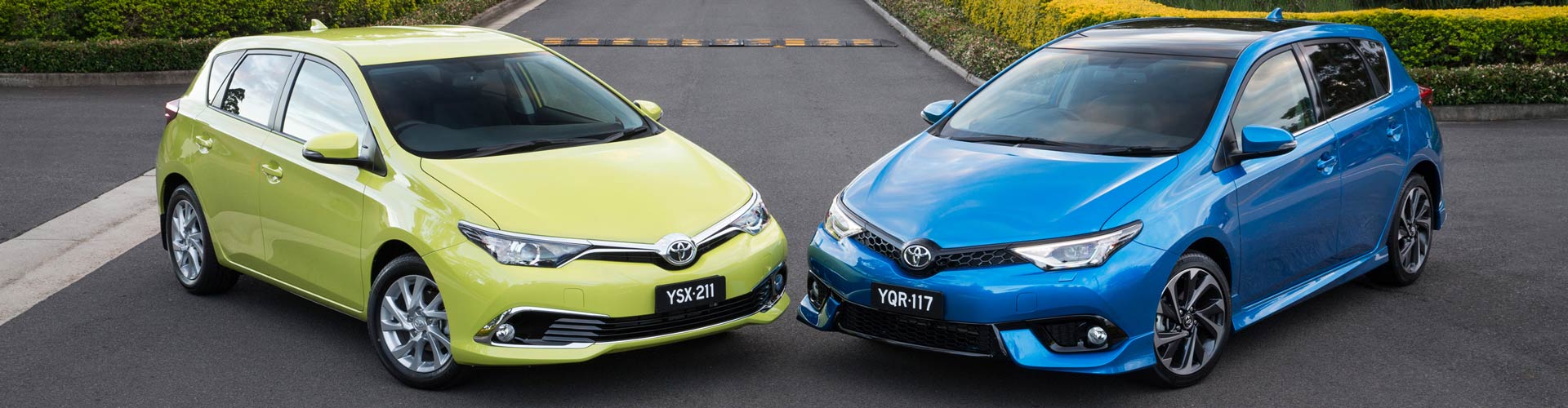 A blue and a yellow 2015 Toyota Corolla Ascent Sport parked in front of some bushes