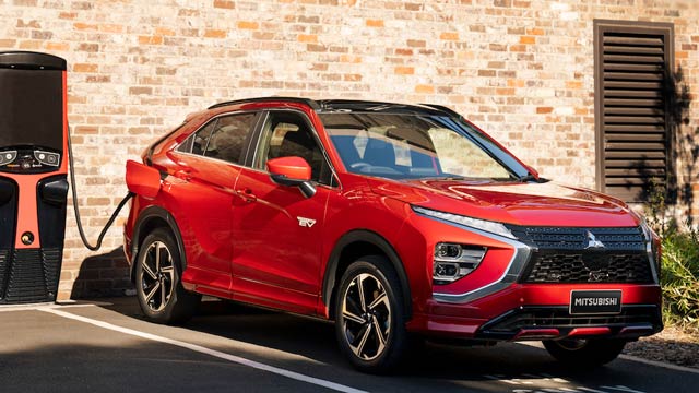A red plug-in hybrid plugged in to a fast charger