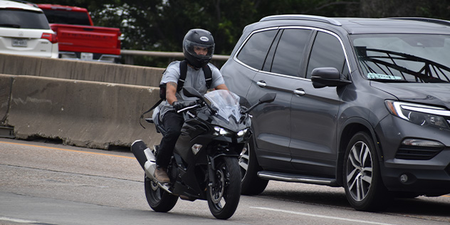 Motorcycle between two cars
