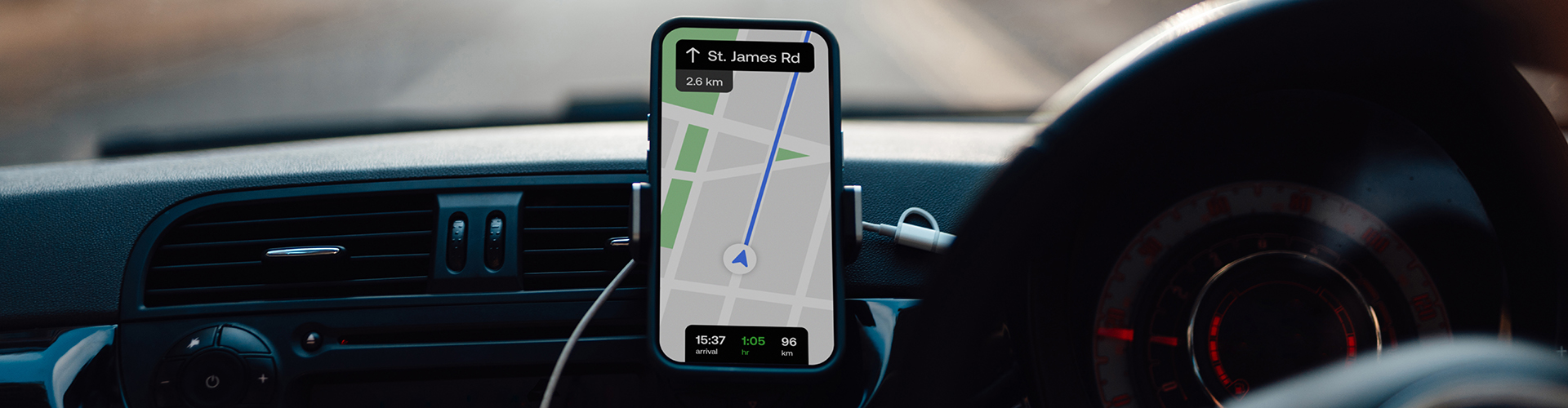 A mobile phone mounted in a cradle in a car