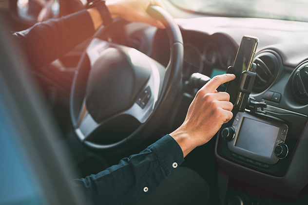 A driver using a mobile phone mounted in a cradle